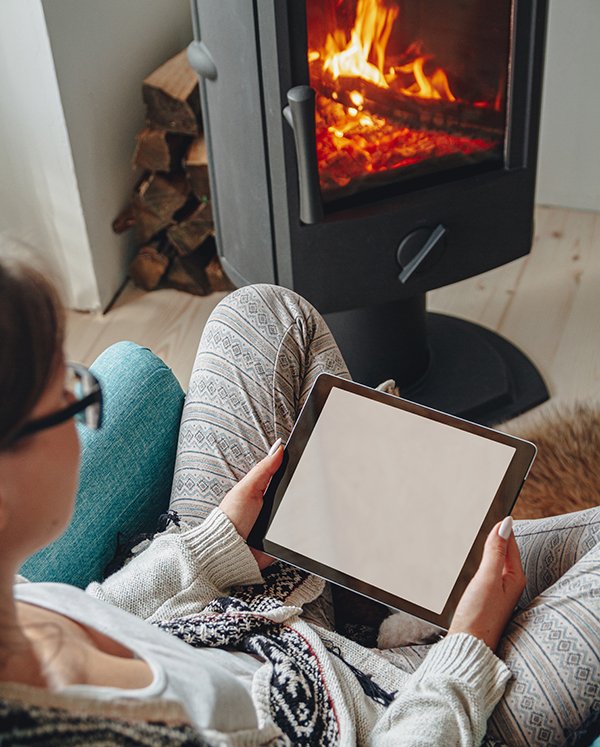 Professional stove service technician maintaining a log burner